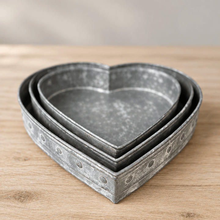 Detail of three nested heart tray rims and weathered silver-gray metal with round side accents