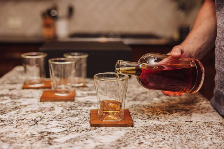 Pouring whiskey into a glass from Old World Whiskey Decanter and Glass Set in Faux Leather Case