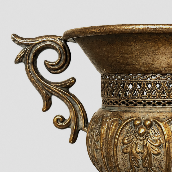 Detail of the aged gold finish, embossed floral body, and ornate handle