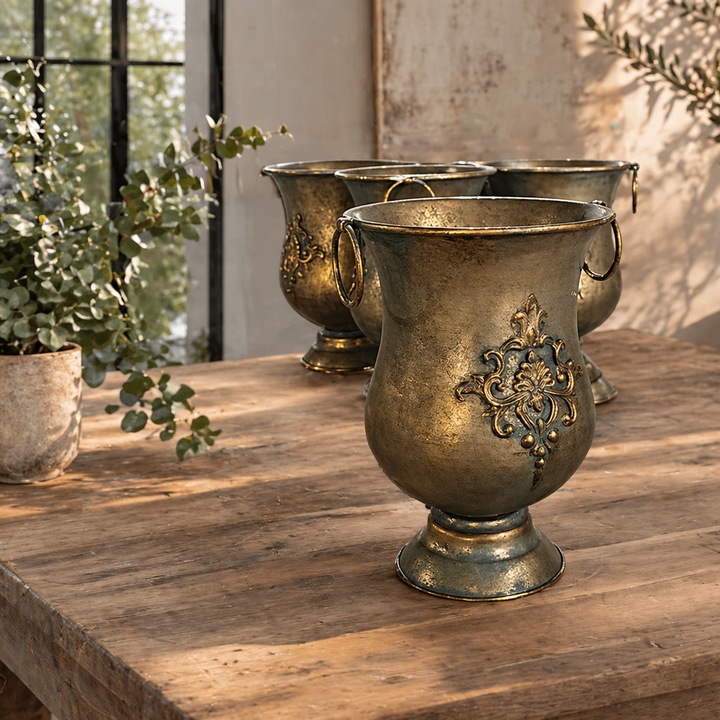Empty Ornate Iron Urn Planter with Ring Handles showing its floral medallion