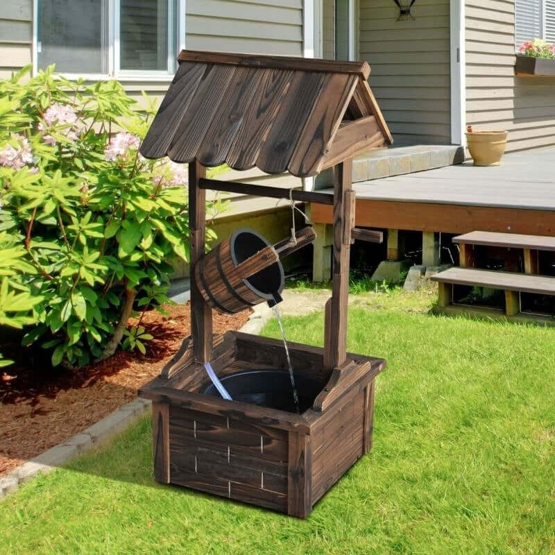 Outdoor Garden Wishing Well Water Fountain with wooden bucket and electric pump in green backyard setting