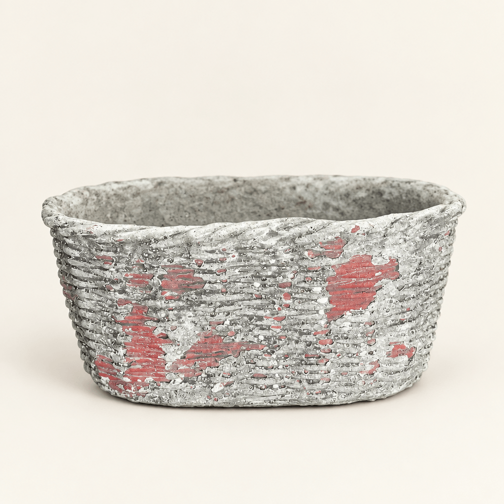 Empty oval concrete planter with basket-weave texture and a weathered finish on ivory.