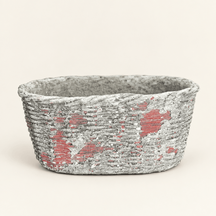 Empty oval concrete planter with basket-weave texture and a weathered finish on ivory.