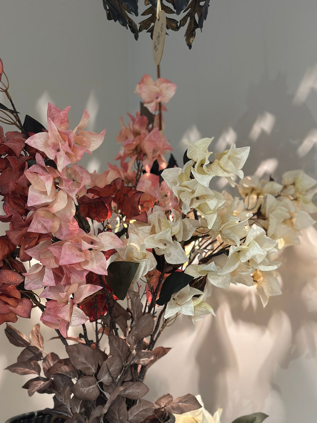 Clustered white, blush, and red bougainvillea faux blooms in a styled arrangement