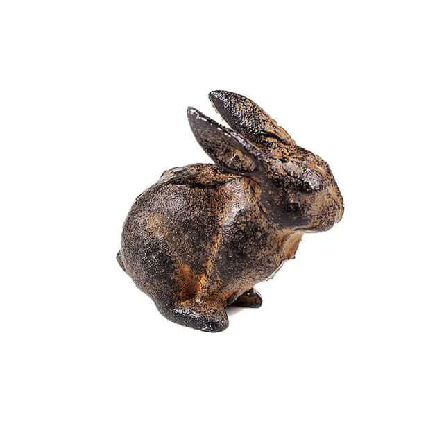 Reverse angle of a sitting cast iron rabbit against white