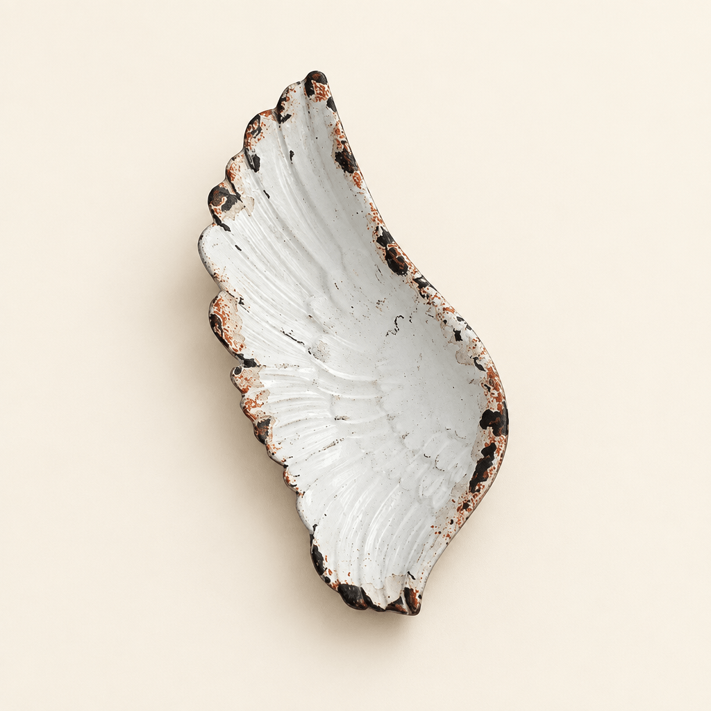 Rustic white pewter angel wing jewelry tray with sculpted feather details on an ivory background