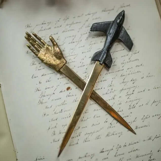 Airplane letter opener with gold-tone blade on correspondence