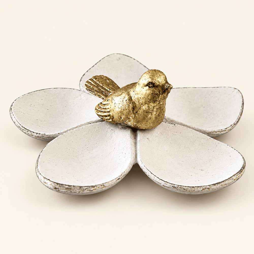 Distressed white five-petal jewelry dish with gold bird on an ivory background