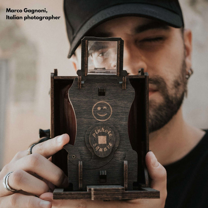 Person demonstrating the Pinhole Square Instant Film Camera DIY Kit, emphasizing its vintage-inspired design.