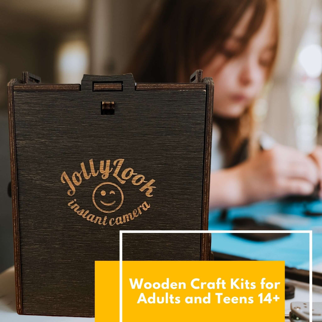 JollyLook instant camera kit with person assembling parts, suitable for adults and teens 14+; wooden craft project for DIY enthusiasts.