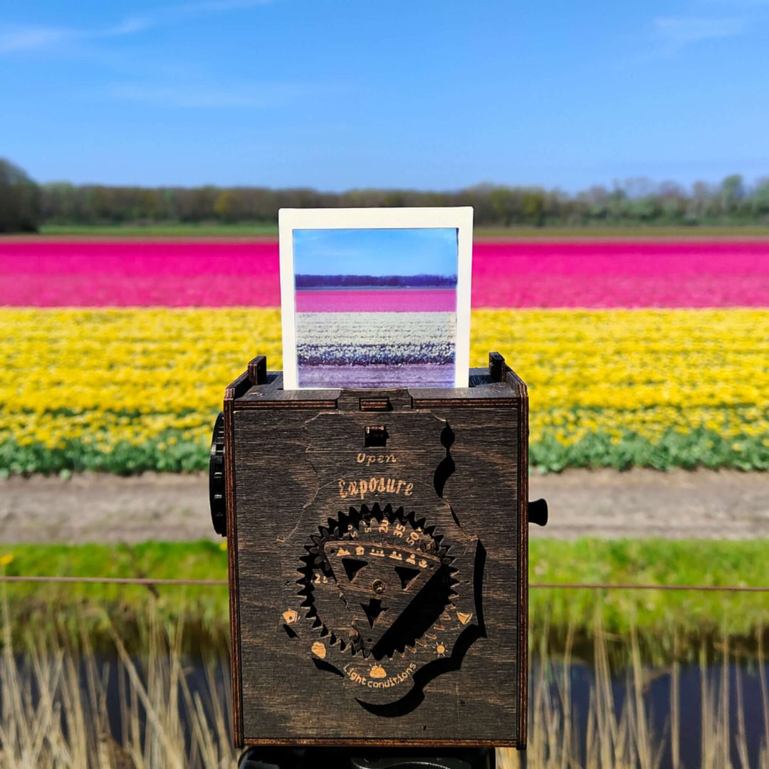 Pinhole Square Instant Film Camera DIY Kit capturing a vibrant landscape with blooming flowers in various colors, showcasing its vintage design.