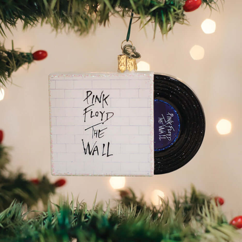 Pink Floyd The Wall Glass Christmas Ornament hanging on a Christmas tree, featuring an iconic album design in handcrafted glass.