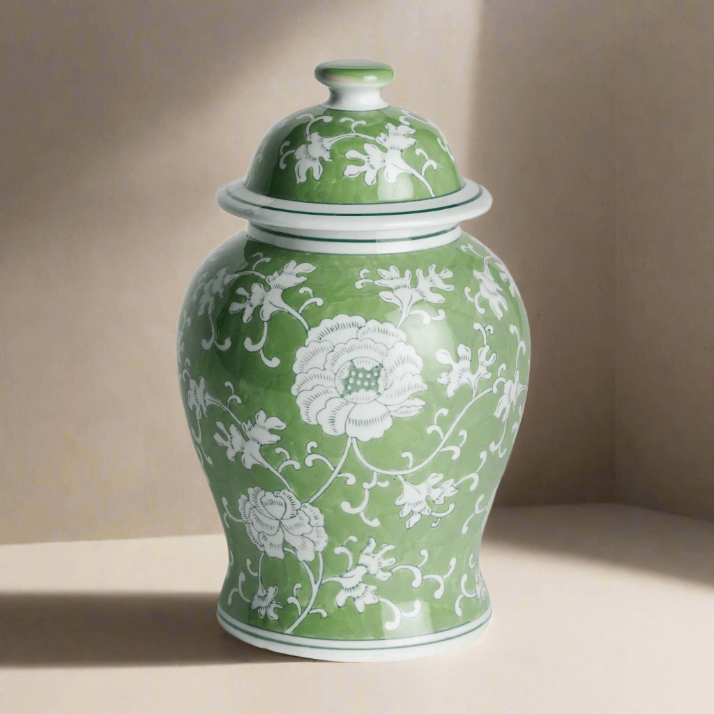Porcelain green chinoiserie lotus ginger jar with lid, featuring intricate white floral design.