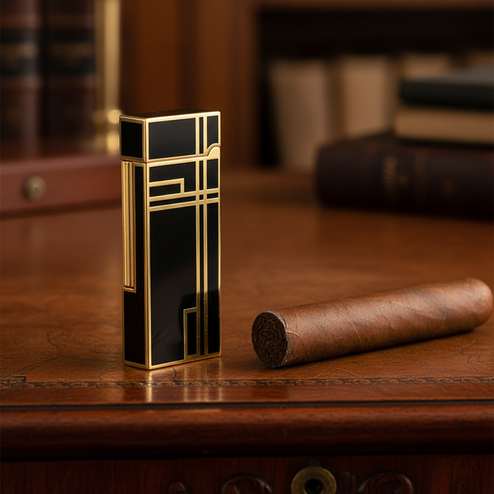 The Prestige Art Deco Lighter in Black and Gold by Jacob Bromwell® on a wooden desk with a cigar nearby.