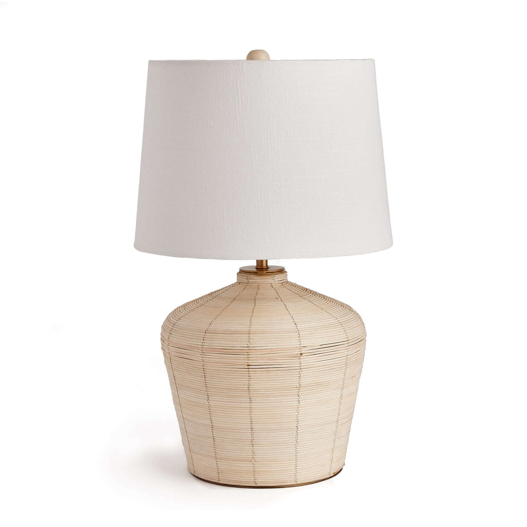 Rattan table lamp with curved base and white shade, showcasing organic elegance and coastal charm.