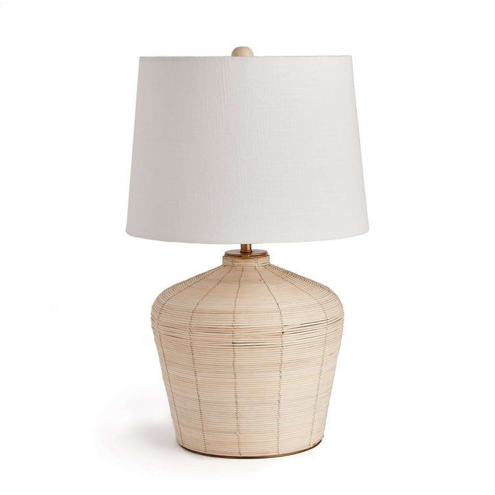 Rattan table lamp with curved base and white shade, showcasing organic elegance and coastal charm.