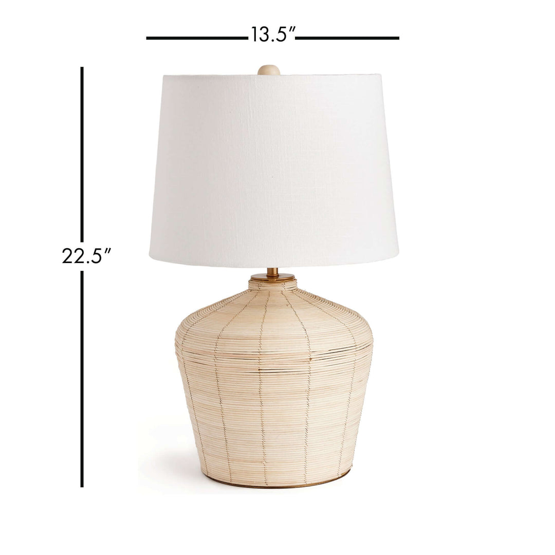 Rattan table lamp with curved base and white shade, showcasing organic elegance and coastal design.