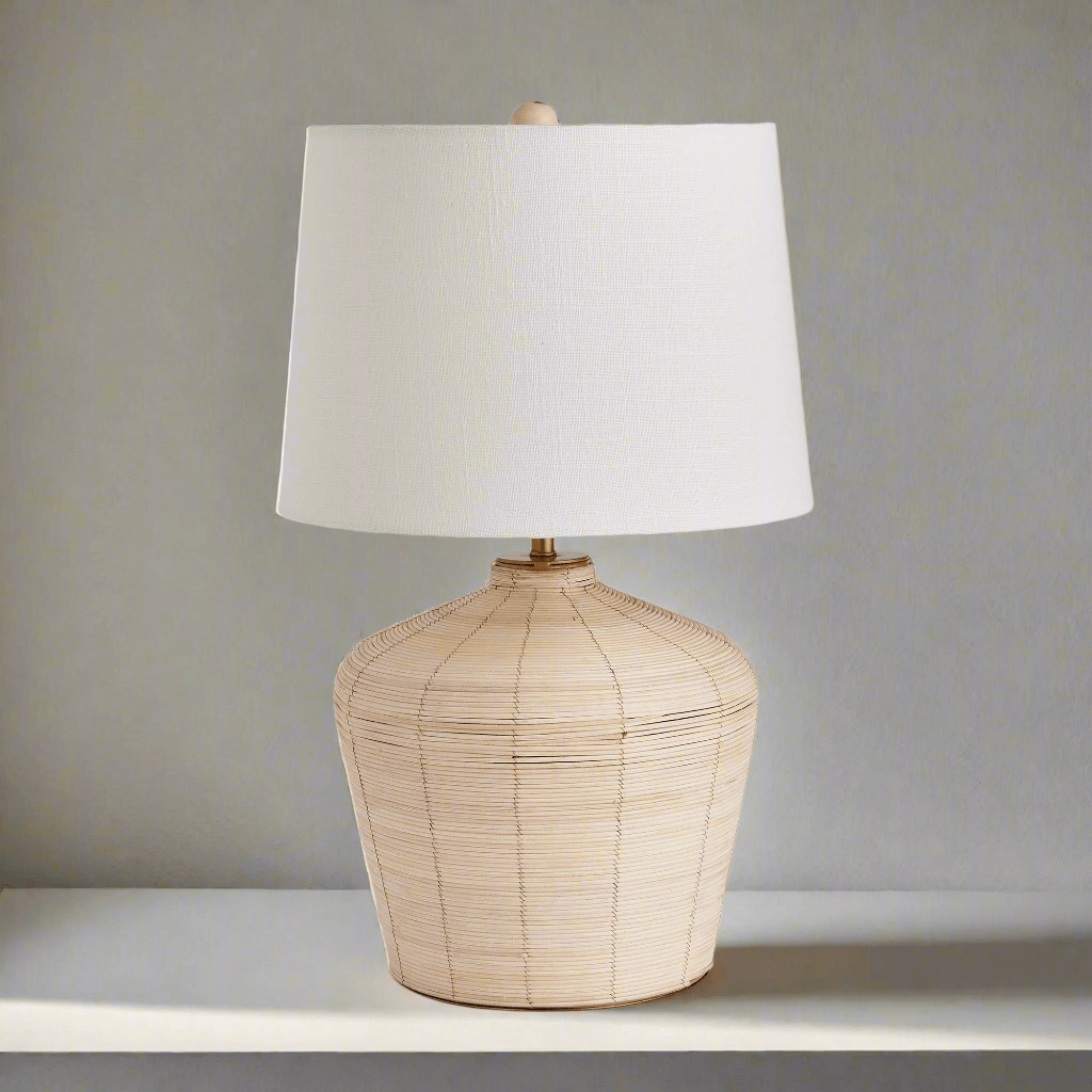 Rattan table lamp with curved base and white shade showcasing organic elegance and coastal nostalgia.