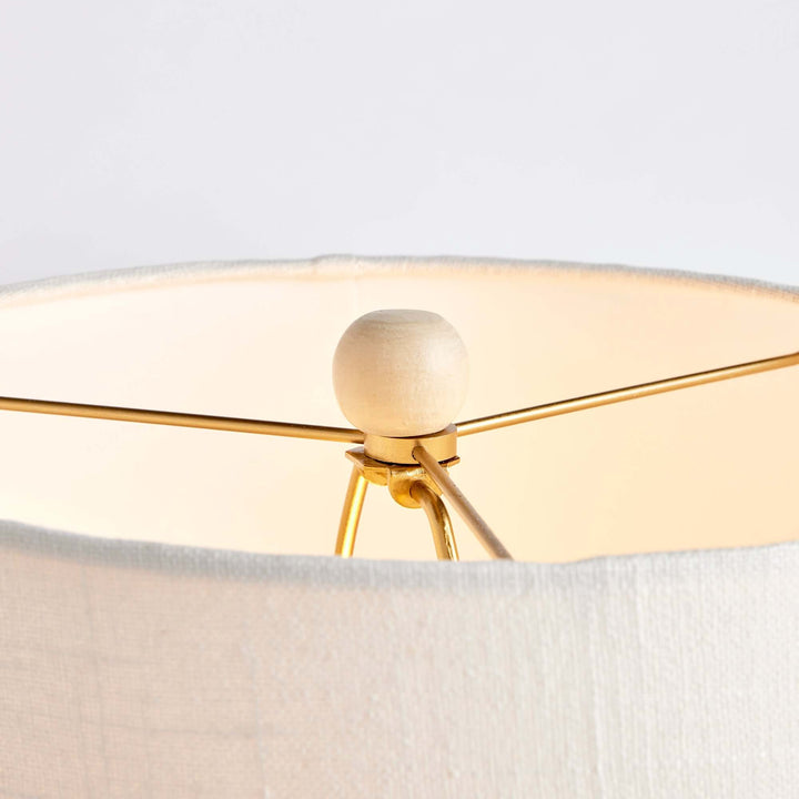 Close-up of the rattan table lamp's white shade and gold support, showcasing elegant craftsmanship and design.