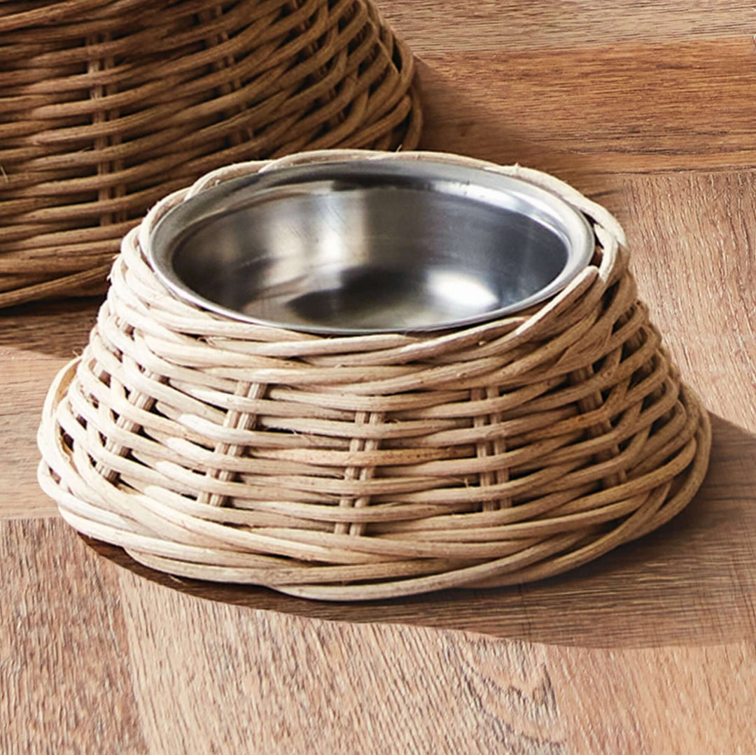 Rattan Pet Bowl with Stainless Steel Insert on wooden floor, showcasing handwoven rustic design for home décor pet dining.