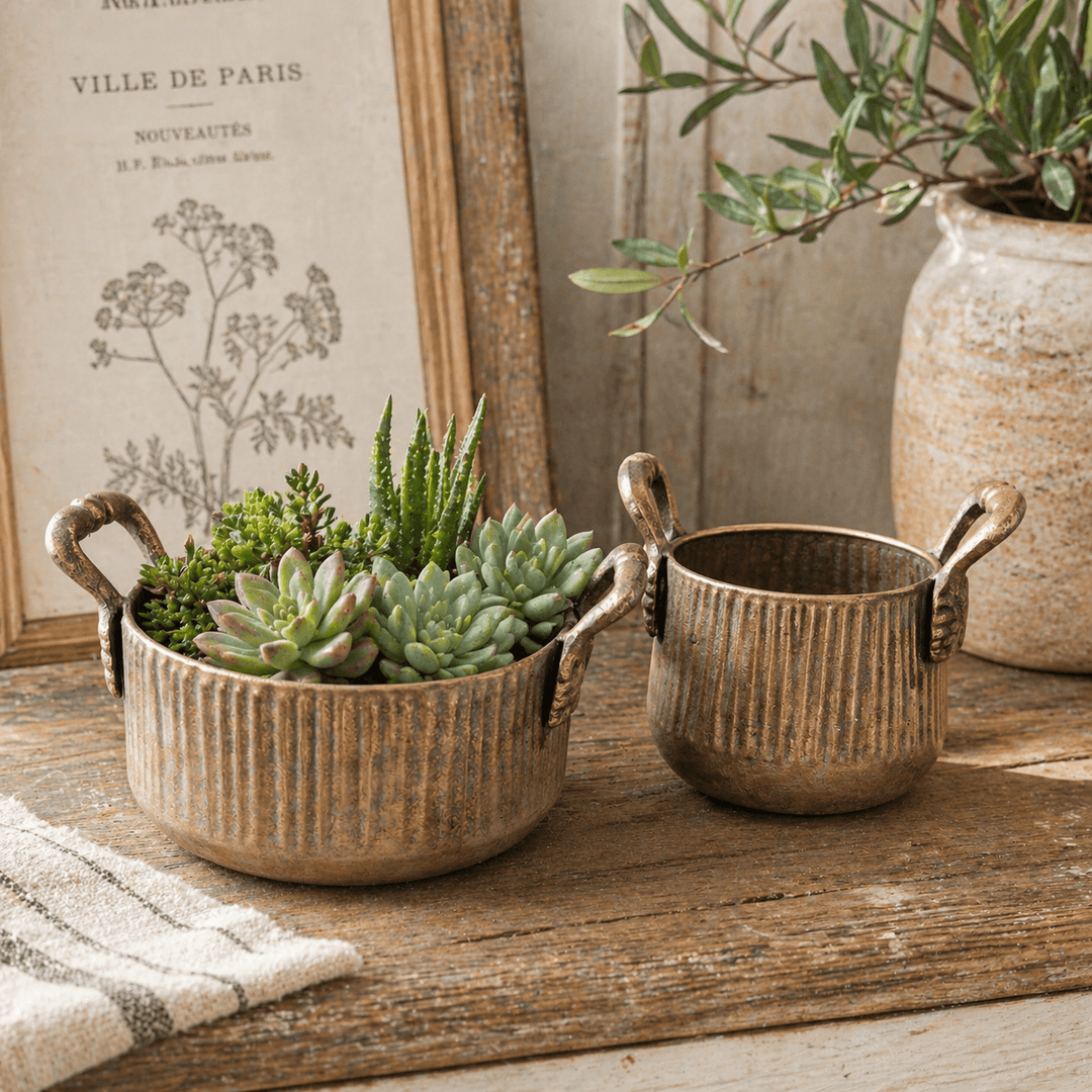 Ribbed Antique Metal Planters with Handles, Set of 2 beside books and greenery