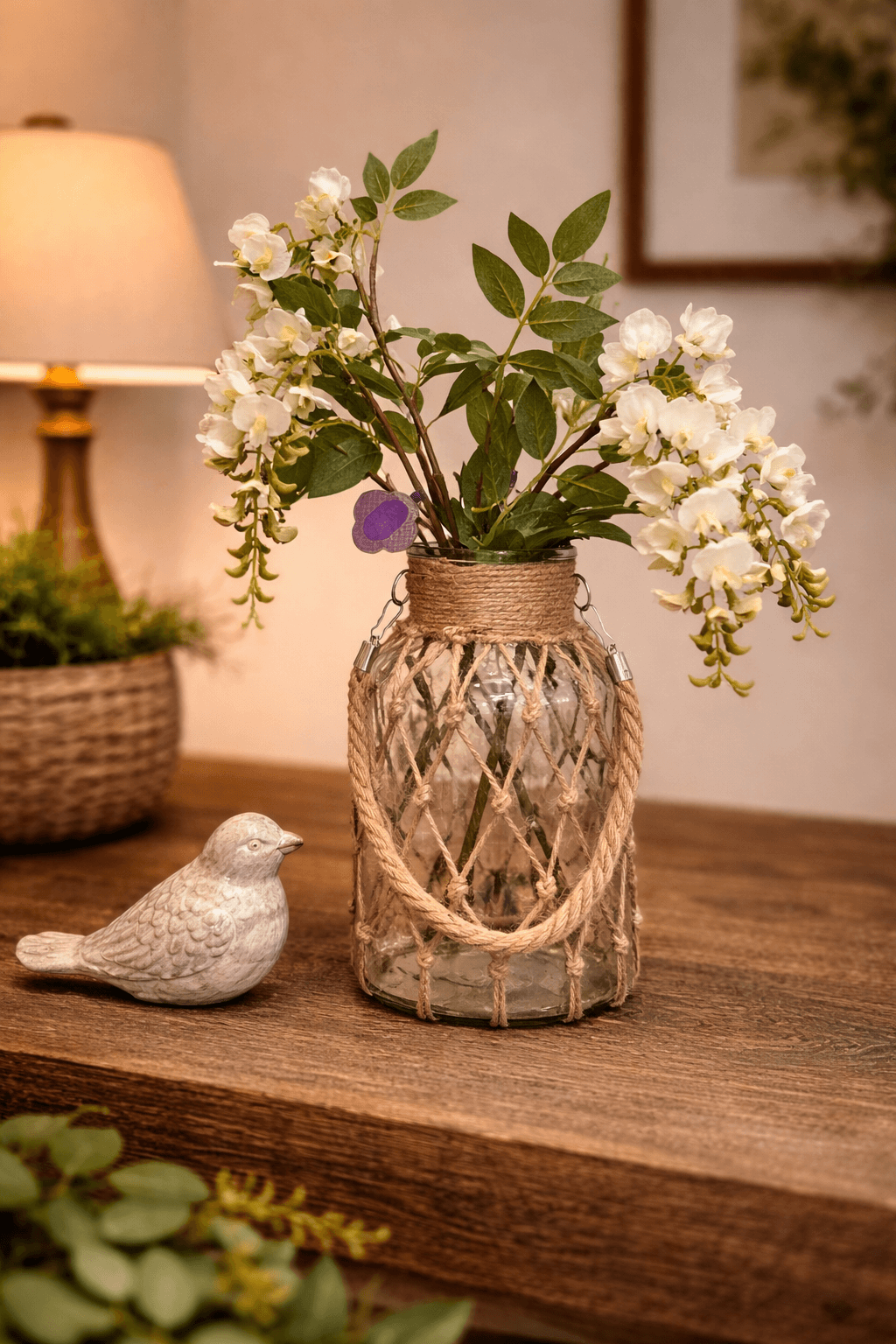 Medium hanging glass vase filled with cascading white blossoms