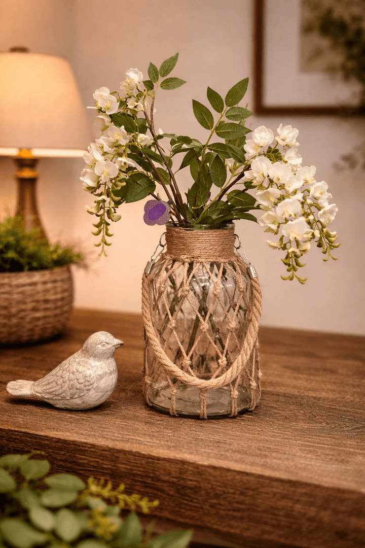 Medium hanging glass vase filled with cascading white blossoms
