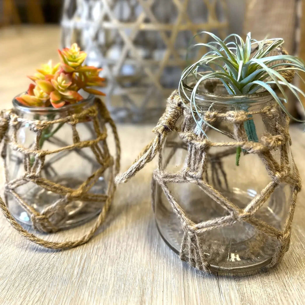 Rope-wrapped glass candle vessels styled with air plants
