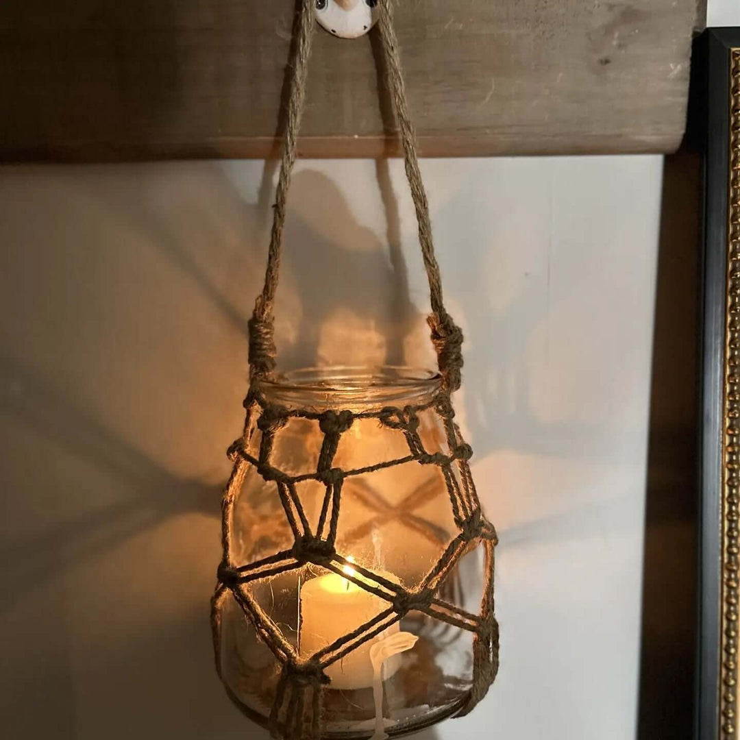 Single hanging glass candle vessel casting patterned light
