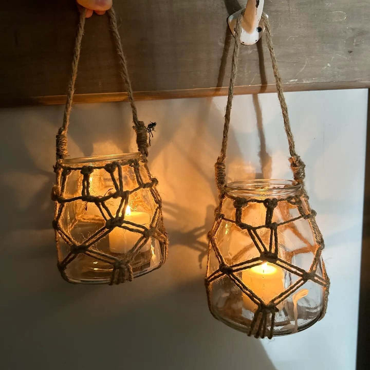 Pair of rope-net glass candle holders suspended with warm flames