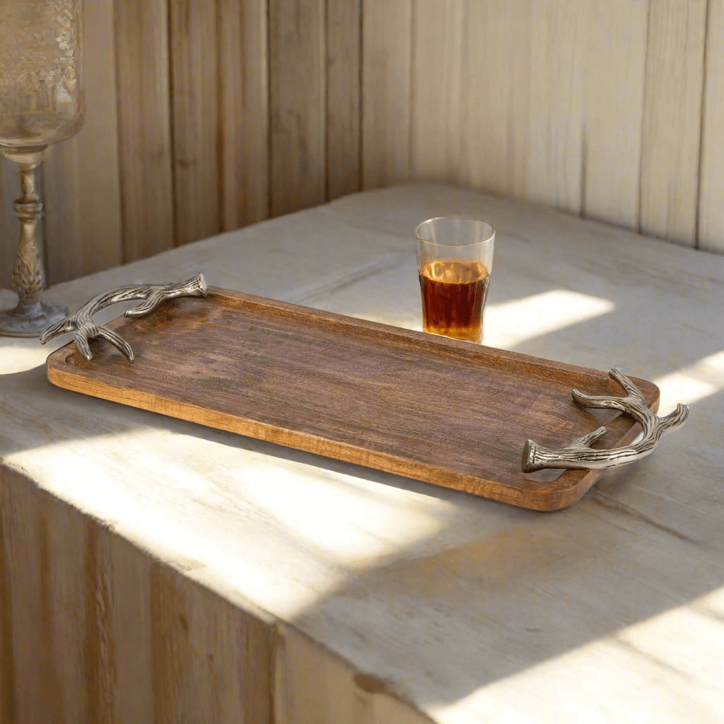 Rustic Antler Mango Wood Serving Tray with Metal Handles on a table with a glass