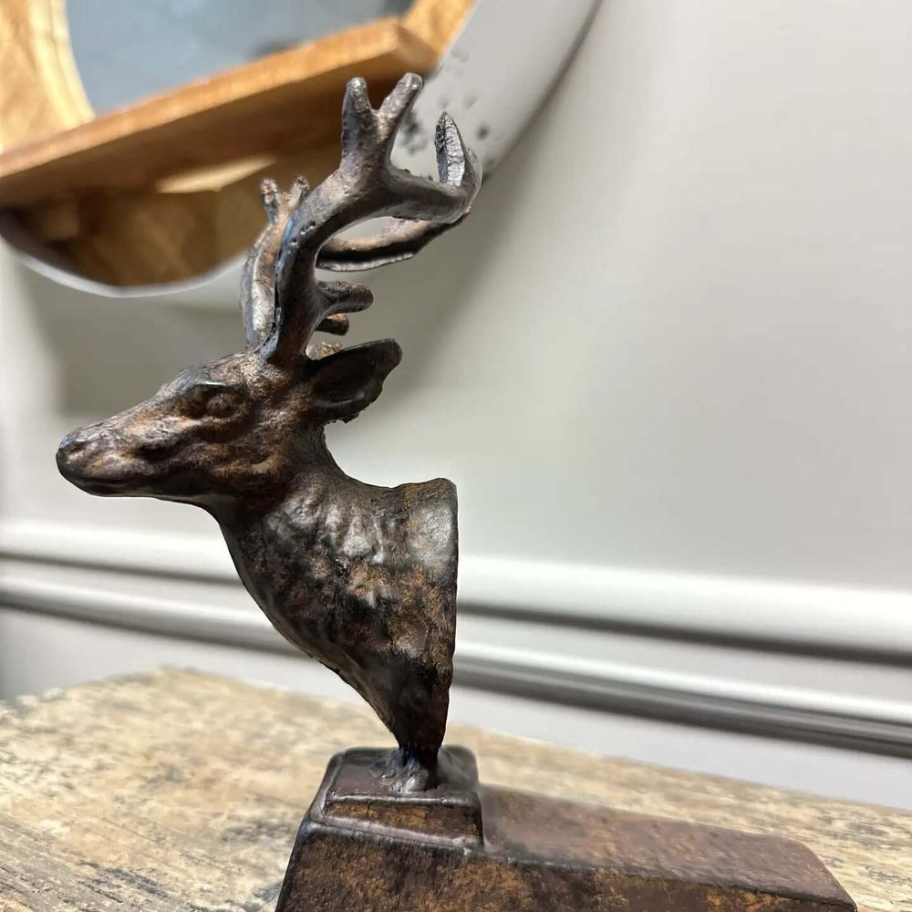 Rustic cast iron deer door stopper with detailed antlers, adding woodland charm and vintage appeal to home decor.