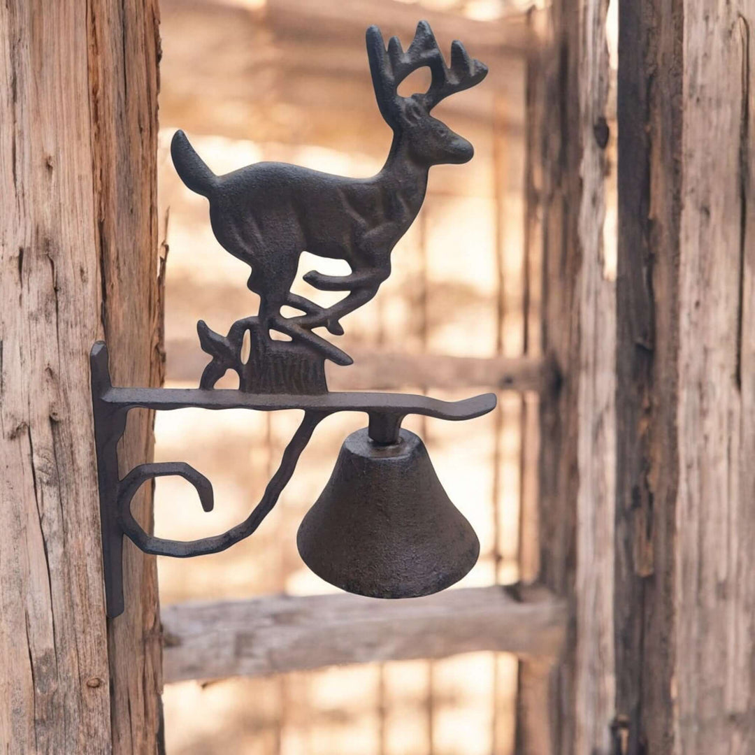 Rustic Cast Iron Deer Wall Bell mounted on wooden surface, featuring a deer figure above a vintage bell, ideal for garden or home decor.