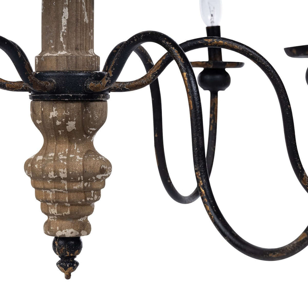 Close-up of rustic French country chandelier with distressed wood and black iron arms.