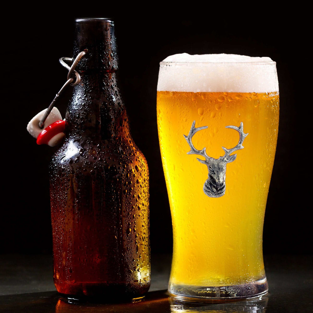 Brown bottle and glass of beer with a deer head logo on a dark background