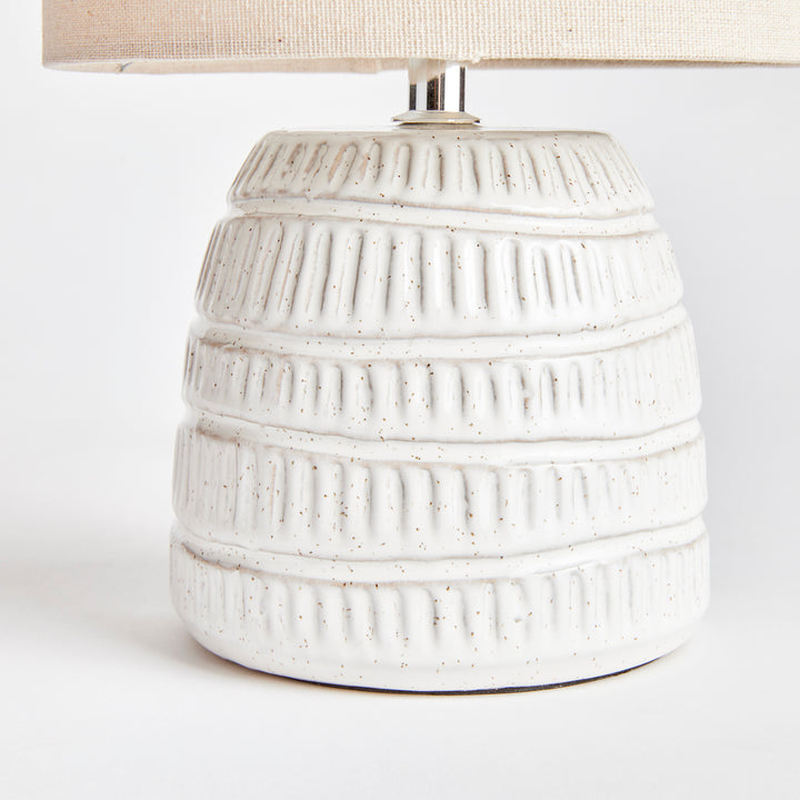 Rustic white glazed pottery table lamp with textured ceramic base and natural charm.