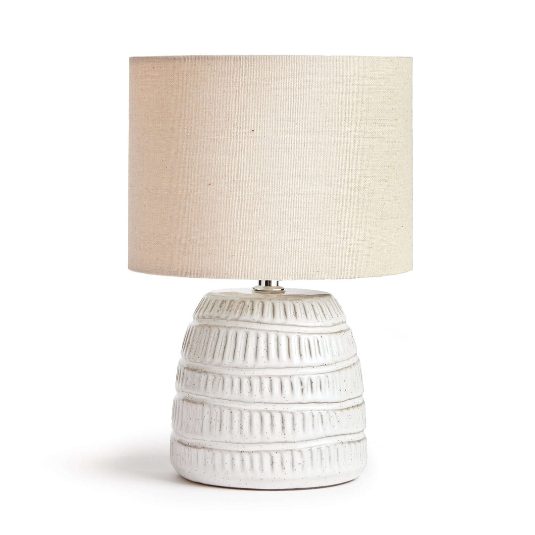 Rustic textured pottery table lamp in white glaze with a linen shade, showcasing handcrafted charm and elegance.