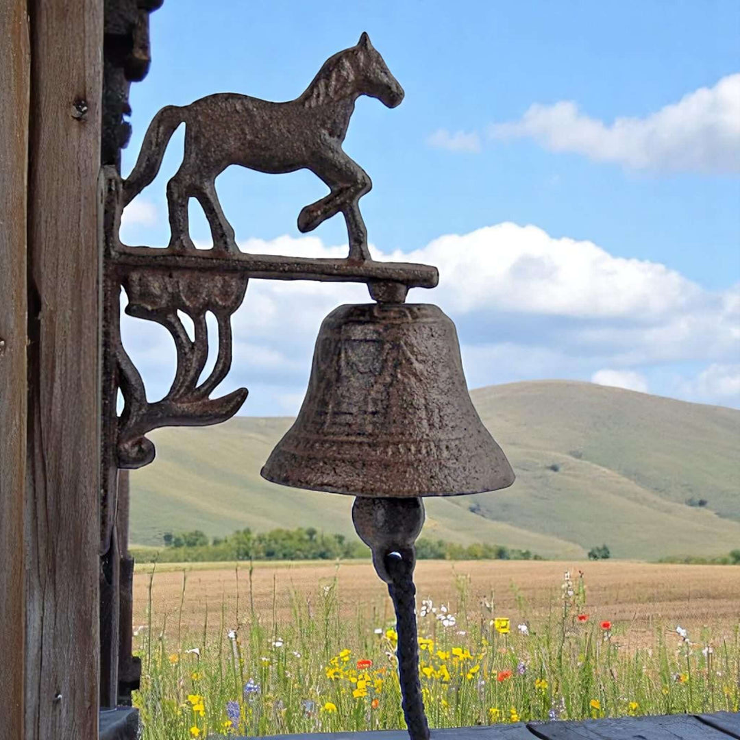 Rustic Western Cast Iron Horse Wall Bell mounted against scenic prairie backdrop.