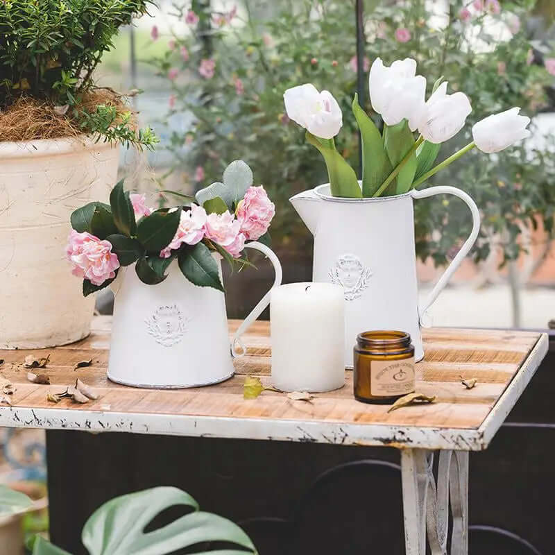Two sizes of rustic white metal pitcher vases with flowers