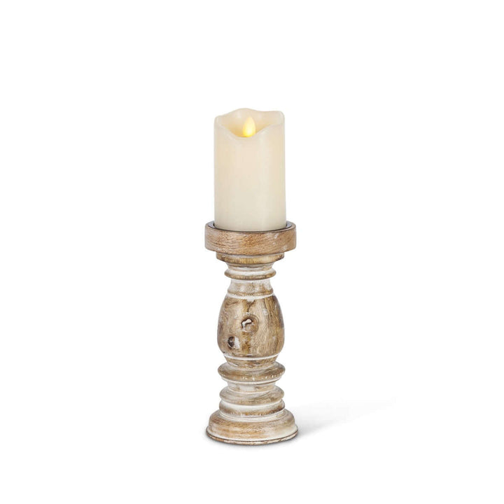 Rustic whitewashed mango wood pillar candle holder with hand-carved design, 9.25 inches tall, holding a lit candle.