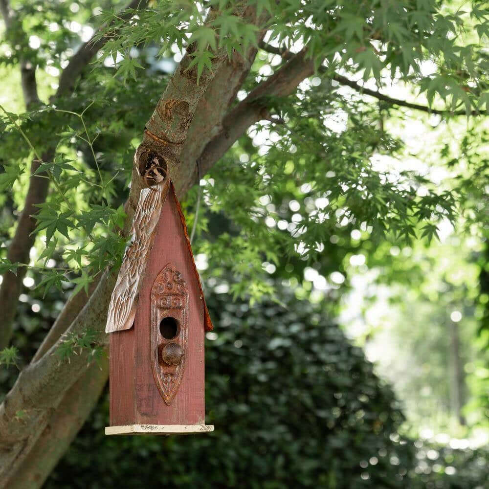 Rustic Brown Wooden Birdhouse with Iron Roof hanging on a tree