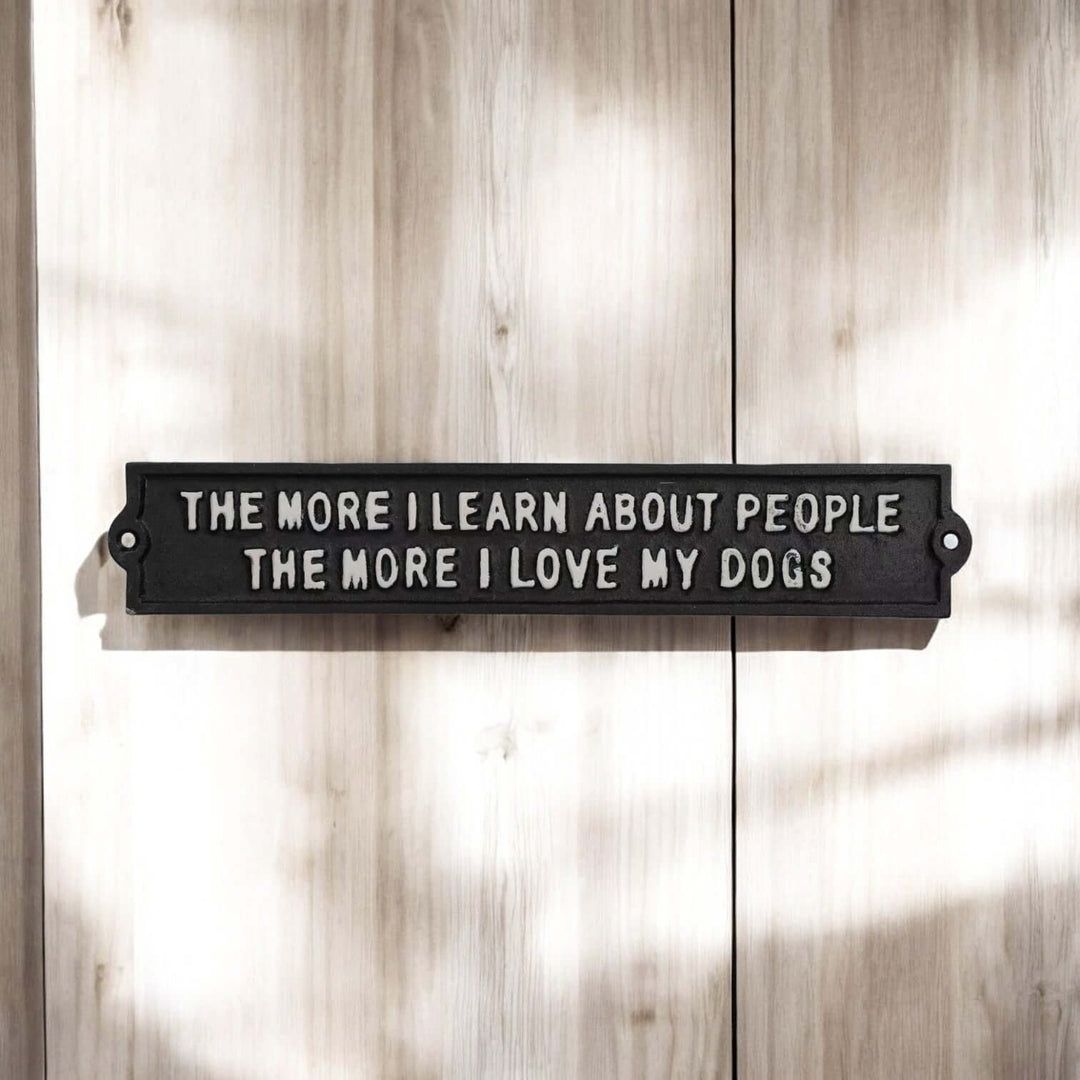 Rustic Cast Iron Dog Lover Wall Sign with heartwarming dog lover phrase in black and white on wood background.