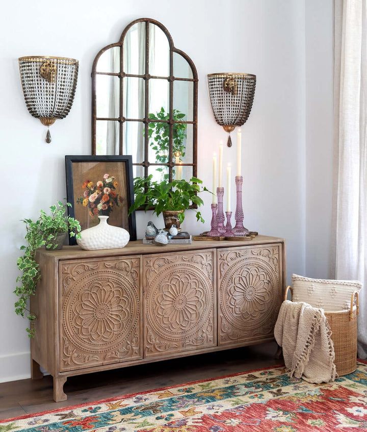 Rustic farmhouse iron windowpane mirror with wooden cabinet and decor.