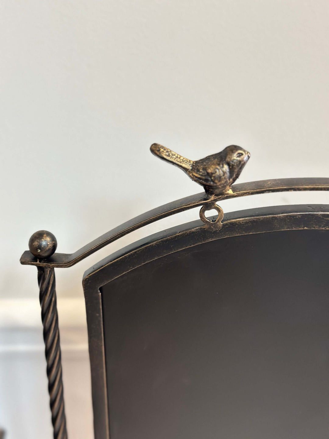 Farmhouse metal chalkboard stand with bird accent, rustic bronze finish, featuring twisted rods and a matte black board.