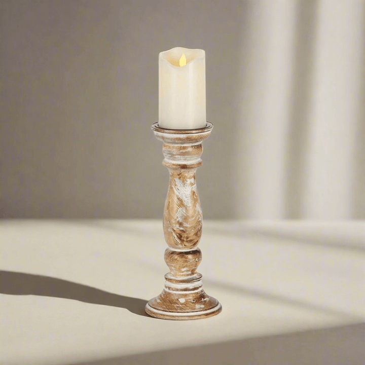 Rustic farmhouse whitewashed wooden candle holder with lit candle on a light background.
