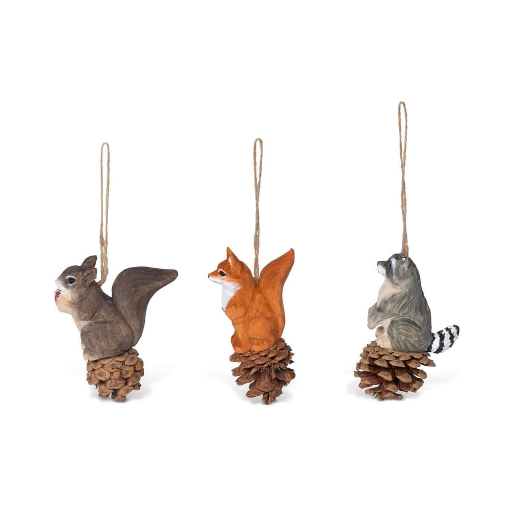 Rustic Woodland Animal Christmas Ornaments set featuring a hand-carved squirrel, fox, and raccoon on pinecones with jute strings.