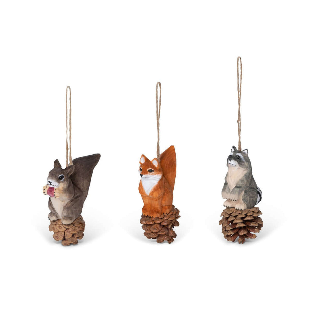Set of 3 rustic woodland animal Christmas ornaments featuring squirrel, fox, and raccoon on pinecones with jute string hangers.