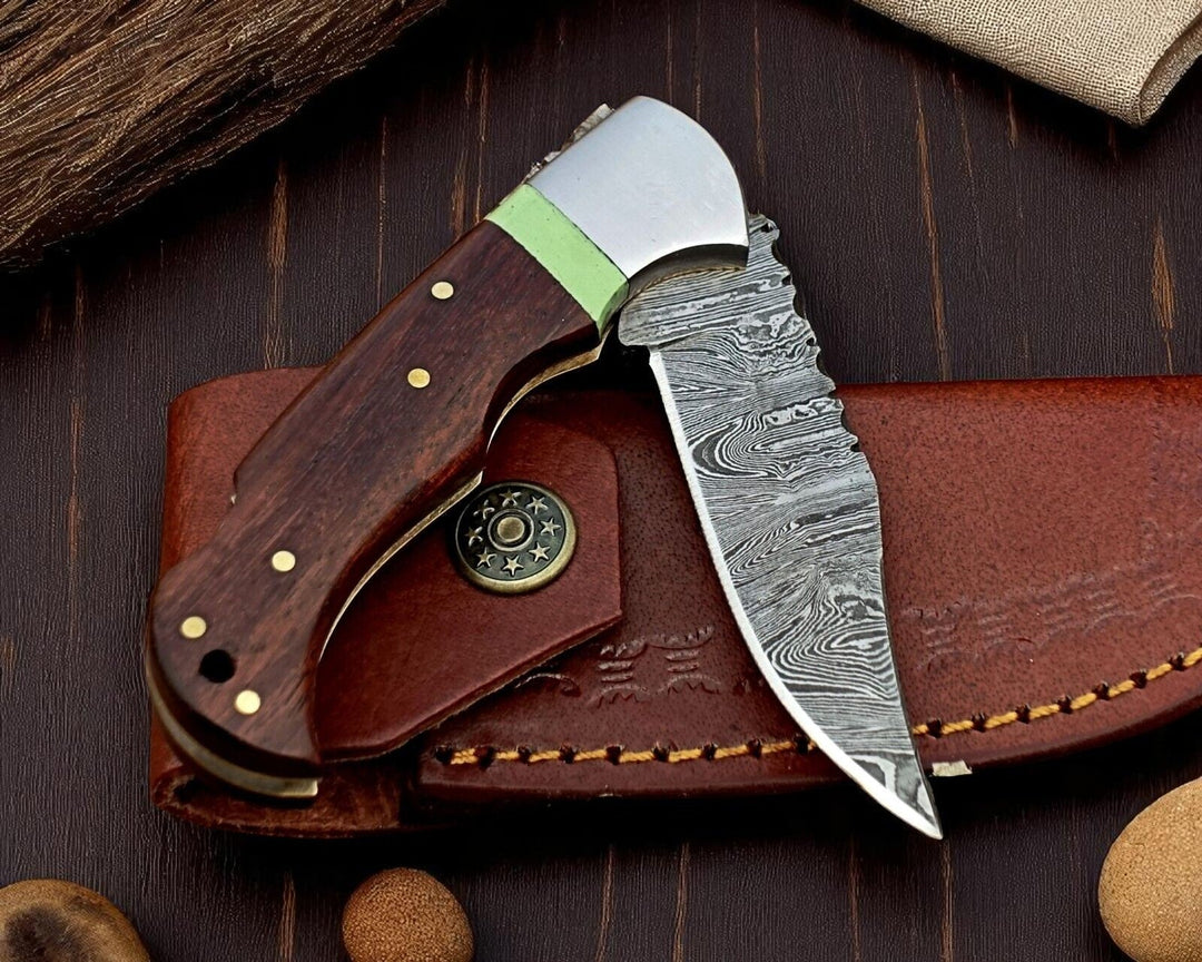 Forked blade knife with wooden handle and leather sheath on a wooden surface