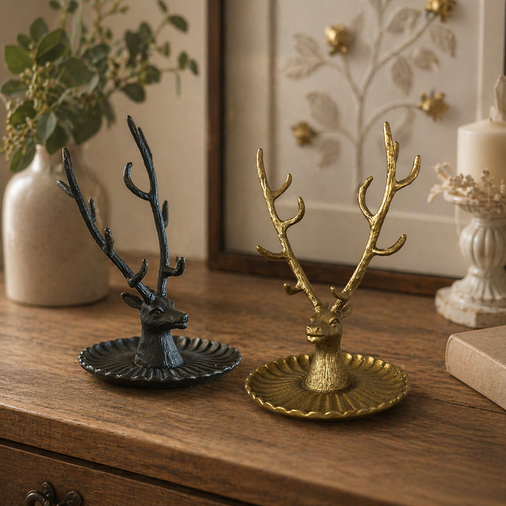 Black and gold sculpted buck jewelry stands styled together on a wooden dresser
