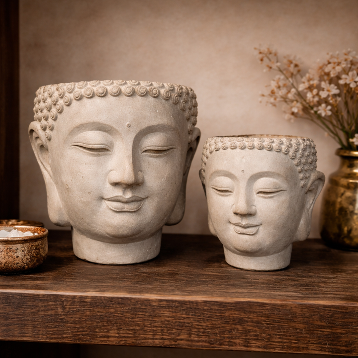 Large and small Sculpted Cement Buddha Wall Planters on a wood shelf